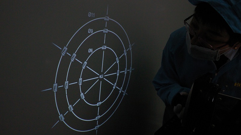An operator performing a reverse projection test. The circles labeled 11, 9, and 6 correspond to image circles of 2/3”, 1/1.8”, and 1/3” sensors, respectively.